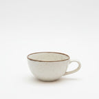 Speckled ceramic cup on a white background