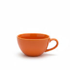 Orange ceramic cup on a white background